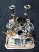 A tray of assorted plated wares, three piece tea service, goblet, pair of candlesticks,