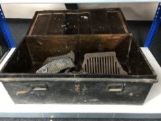 An early twentieth century tin trunk containing fire grates and fronts