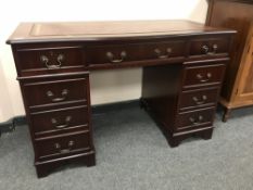 A reproduction mahogany twin pedestal desk with tooled leather top,