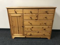 A pine sideboard fitted eight drawers and a cupboard