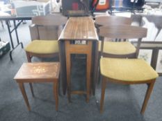 A mid 20th century melamine drop leaf table and three chairs and a music table