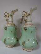 A pair of continental encrusted and gilded ewers