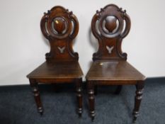 A pair of early Victorian oak shield back hall chairs