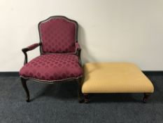 A French style arm chair in maroon with an over-sized footstool