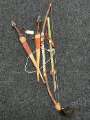 Two African tribal swords in leather scabbards and a tribal bow with quiver of arrows
