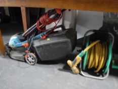 A Gardena electric mower and a hose on reel