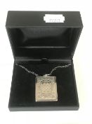 A silver pendant on chain