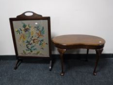 A walnut kidney shaped coffee table and an oak fire screen