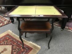 A Victorian mahogany turn over top games table with baize lined interior