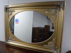 A gilt framed overmantel mirror with oval glass