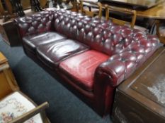 A red button leather Chesterfield three seater settee