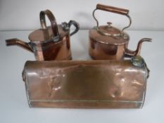 An antique copper hot water flask together with a copper watering can and kettle