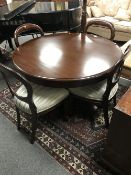 A Barker and Stonehouse mahogany circular dining table together with a set of four balloon backed