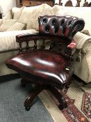 An oxblood buttoned leather swivel office chair