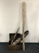 A wicker dome topped box containing two tribal spears,