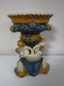 A Majolica style table centre piece surrounded by cherubs