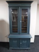 An early 20th century painted continental oak glazed door bookcase fitted cupboards beneath