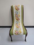 A Victorian mahogany nursing chair upholstered in a floral tapestry fabric