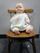 An early 20th century child's chair together with a plastic doll