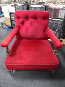 A late Victorian mahogany armchair upholstered in a red buttoned fabric