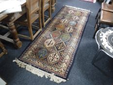 A fringed runner of geometric design on blue ground