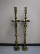 A pair of brass floor standing candlesticks