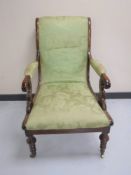 A Victorian scroll-arm armchair upholstered in a green brocade