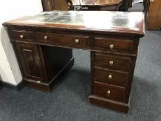 An Edwardian oak twin pedestal leather topped desk