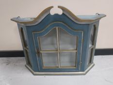 A painted glazed door wall cabinet