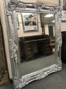 An ornate silvered mirror, 123 cm x 155 cm.