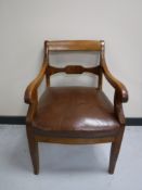 An antique mahogany scroll-arm armchair
