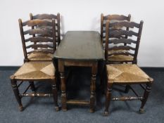 An antique oak gate leg table together with a set of four rush seated ladder back chairs