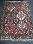 A fringed woollen Persian rug of geometric design