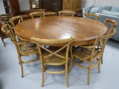 An impressive circular hardwood dining table to seat eight people,