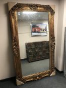 A large gilded ornate framed mirror, 125 cm x 214 cm.