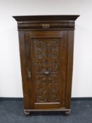 An early 20th century continental oak carved door cabinet fitted a drawer