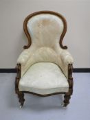 A Victorian mahogany framed armchair upholstered in a cream floral fabric