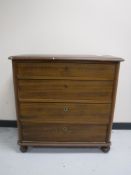 An antique pine four drawer chest on bun feet