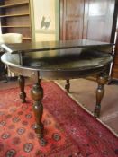 A circular oak dining table with three extension leaves