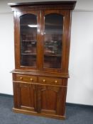A Victorian mahogany glazed door bookcase fitted cupboards and drawers beneath