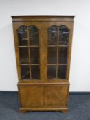 A walnut glazed door bookcase fitted cupboards beneath