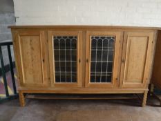 A blonde oak four door sideboard