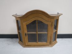 An early 20th century oak glazed door wall cabinet