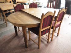 A circular continental oak extending table with two leaves and four chairs