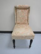 An early 20th century bedroom chair upholstered in a pink floral fabric