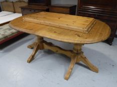 An oval pine dining table with two extension leaves