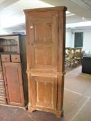 An antique pine double door corner cupboard
