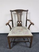 A carved Georgian armchair with a tapestry upholstered seat