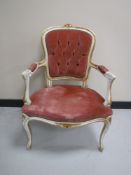 A white and gilt French armchair upholstered in a pink button dralon