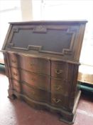 An oak serpentine fronted bureau